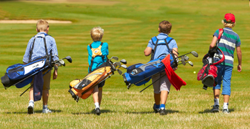 Four Young Boys Walking With Golf Bags